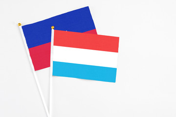 Luxembourg and Haiti stick flags on white background. High quality fabric, miniature national flag. Peaceful global concept.White floor for copy space.