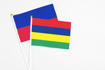 Mauritius and Haiti stick flags on white background. High quality fabric, miniature national flag. Peaceful global concept.White floor for copy space.