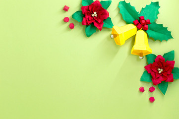 Vignette of paper poinsettia flowers and Christmas bells