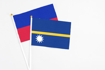 Nauru and Haiti stick flags on white background. High quality fabric, miniature national flag. Peaceful global concept.White floor for copy space.