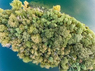 above the small island with trees on the lake