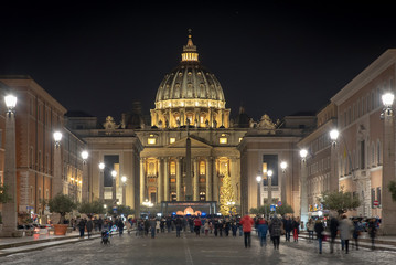 Fototapeta premium View of the Papal Basilica of St. Peter's in the Vatican illuminated at night (St. Peter's Cathedral) in Rome, Italy.
