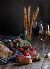 still life of jamon and cheese with moldy wine red and white and salty sticks