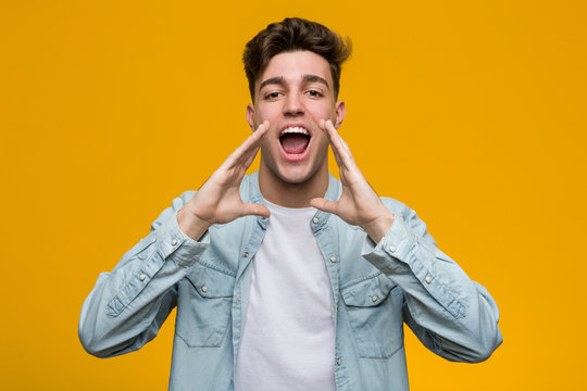 Young Handsome Student Wearing A Denim Shirt Shouting Excited To Front.