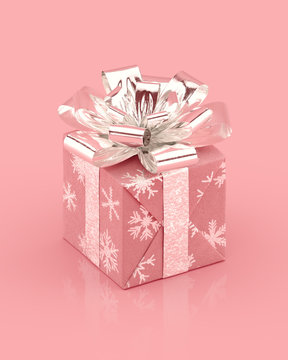 Pink giftbox with shiny silver bow and ribbons. Snowflakes pattern on paper. Realistic 3D rendering.
