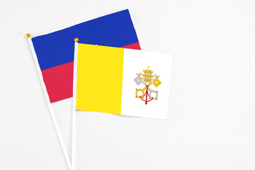 Vatican City and Haiti stick flags on white background. High quality fabric, miniature national...