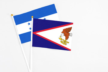 American Samoa and Honduras stick flags on white background. High quality fabric, miniature national flag. Peaceful global concept.White floor for copy space.