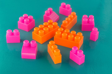Obraz premium orange and pink bricks of a different size children's designer on a green background
