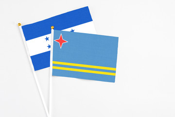 Fototapeta premium Aruba and Honduras stick flags on white background. High quality fabric, miniature national flag. Peaceful global concept.White floor for copy space.