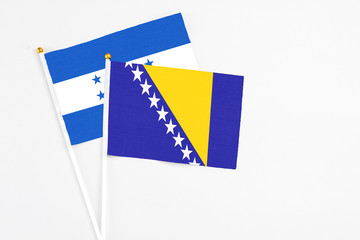 Bosnia Herzegovina and Honduras stick flags on white background. High quality fabric, miniature...