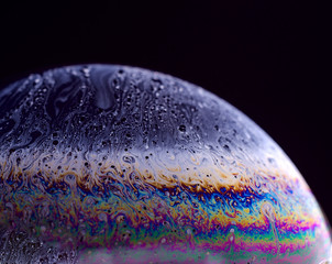 Abstract macro of soap bubble. Close up surface of soap bubble seems like planet in space. Creative background.