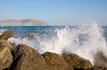 A splash of sea waves on the coast near the stones.