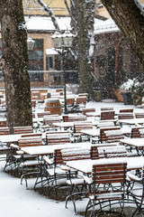 Outdoor cafe without visitors under falling snow