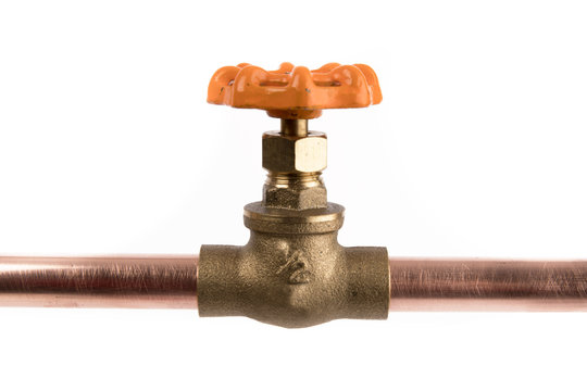 a brass plumbing shut off cock attached to a copper pipe isolated on white