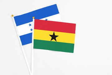 Ghana and Honduras stick flags on white background. High quality fabric, miniature national flag. Peaceful global concept.White floor for copy space.
