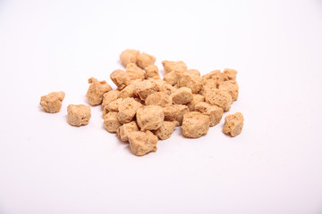 Proteína de soja texturizada gruesa sobre fondo blanco.