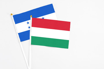 Hungary and Honduras stick flags on white background. High quality fabric, miniature national flag. Peaceful global concept.White floor for copy space.