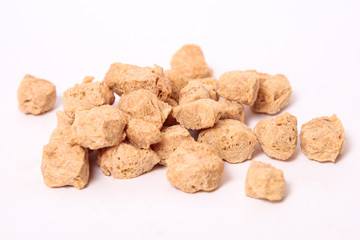 Proteína de soja texturizada gruesa sobre fondo blanco.
