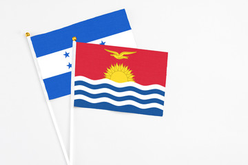 Kiribati and Honduras stick flags on white background. High quality fabric, miniature national flag. Peaceful global concept.White floor for copy space.