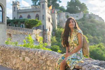 Fototapeta premium Young Indian woman sitting on the wall on the mountain