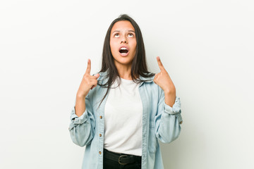Obraz premium Young hispanic woman pointing upside with opened mouth.