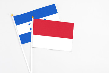 Monaco and Honduras stick flags on white background. High quality fabric, miniature national flag. Peaceful global concept.White floor for copy space.