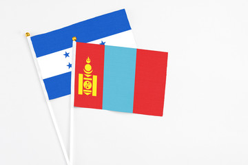 Mongolia and Honduras stick flags on white background. High quality fabric, miniature national flag. Peaceful global concept.White floor for copy space.