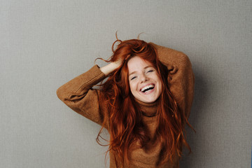 Happy lively young woman laughing at the camera