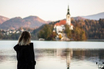 young woman looking to church on Bled lake in The Slovenia