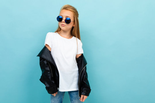 Copyspace photo of cool stylish schoolgirl on a blue background in a white t-shirt and a black jacket