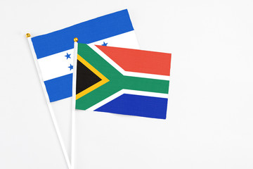 South Africa and Honduras stick flags on white background. High quality fabric, miniature national flag. Peaceful global concept.White floor for copy space.