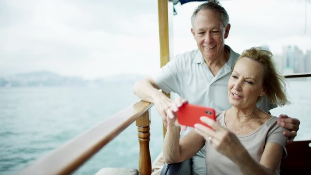 Senior couple taking travel photos with smart phone