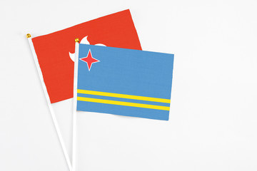 Aruba and Hong Kong stick flags on white background. High quality fabric, miniature national flag. Peaceful global concept.White floor for copy space.
