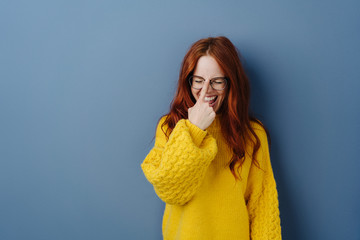 Laughing young woman adjusting her glasses