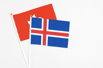 Iceland and Hong Kong stick flags on white background. High quality fabric, miniature national flag. Peaceful global concept.White floor for copy space.