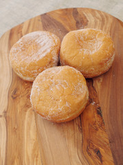Three fresh jam doughnut on a wooden board, Pastry product.