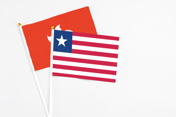 Liberia and Hong Kong stick flags on white background. High quality fabric, miniature national flag. Peaceful global concept.White floor for copy space.