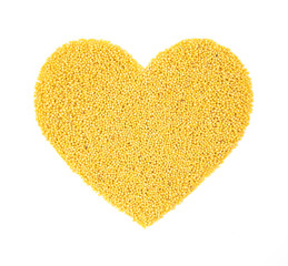 Heart shaped millet groats isolated on white background