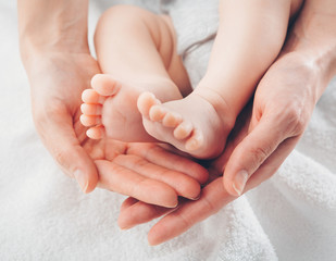 Baby feet in mother hands. Mom and her Child. Happy Family concept