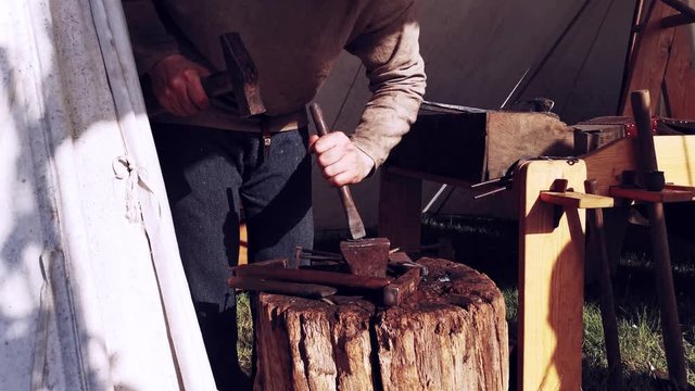 Ein Schmied stellt Waffen auf einem Mittelalter Spektakel her