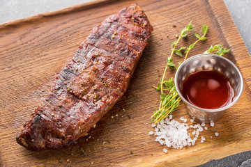 Grilled marinated beef flank steak on wooden board