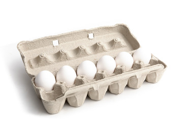 a one dozen egg carton half full, or half empty isolated on white