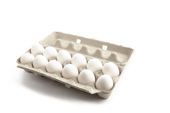 A Dozen Eggs In A Cardboard Carton Isolated On White