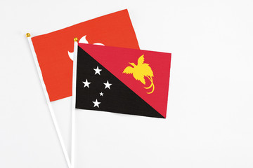 Papua New Guinea and Hong Kong stick flags on white background. High quality fabric, miniature national flag. Peaceful global concept.White floor for copy space.
