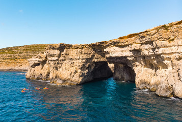 Fototapeta na wymiar Group of kayakers and cave. Comino island. Drone landscape. Europe. Malta 