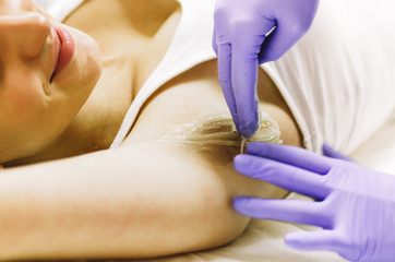 woman doing hot sugar wax hair removal