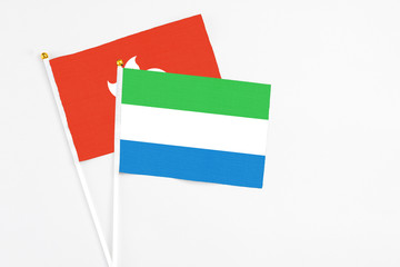 Sierra Leone and Hong Kong stick flags on white background. High quality fabric, miniature national flag. Peaceful global concept.White floor for copy space.