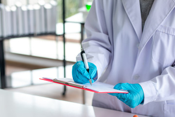 close up of scientist recording at note in lab