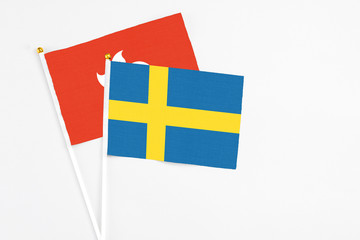 Sweden and Hong Kong stick flags on white background. High quality fabric, miniature national flag. Peaceful global concept.White floor for copy space.