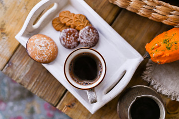 Autumn, pumpkins, hot steaming cup of coffee on a wooden table background. Seasonal, morning coffee with biscuit cinnamon cookies, sunday relaxing and still life concept
